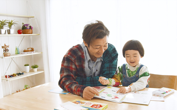 つるの剛士さんと子どもがいっしょに絵本を読んでいるひとコマの画像です